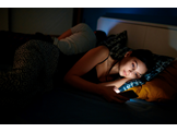 Woman checking smartphone at bedtime